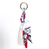 Bag charm tassel in white with a red twilly scarf